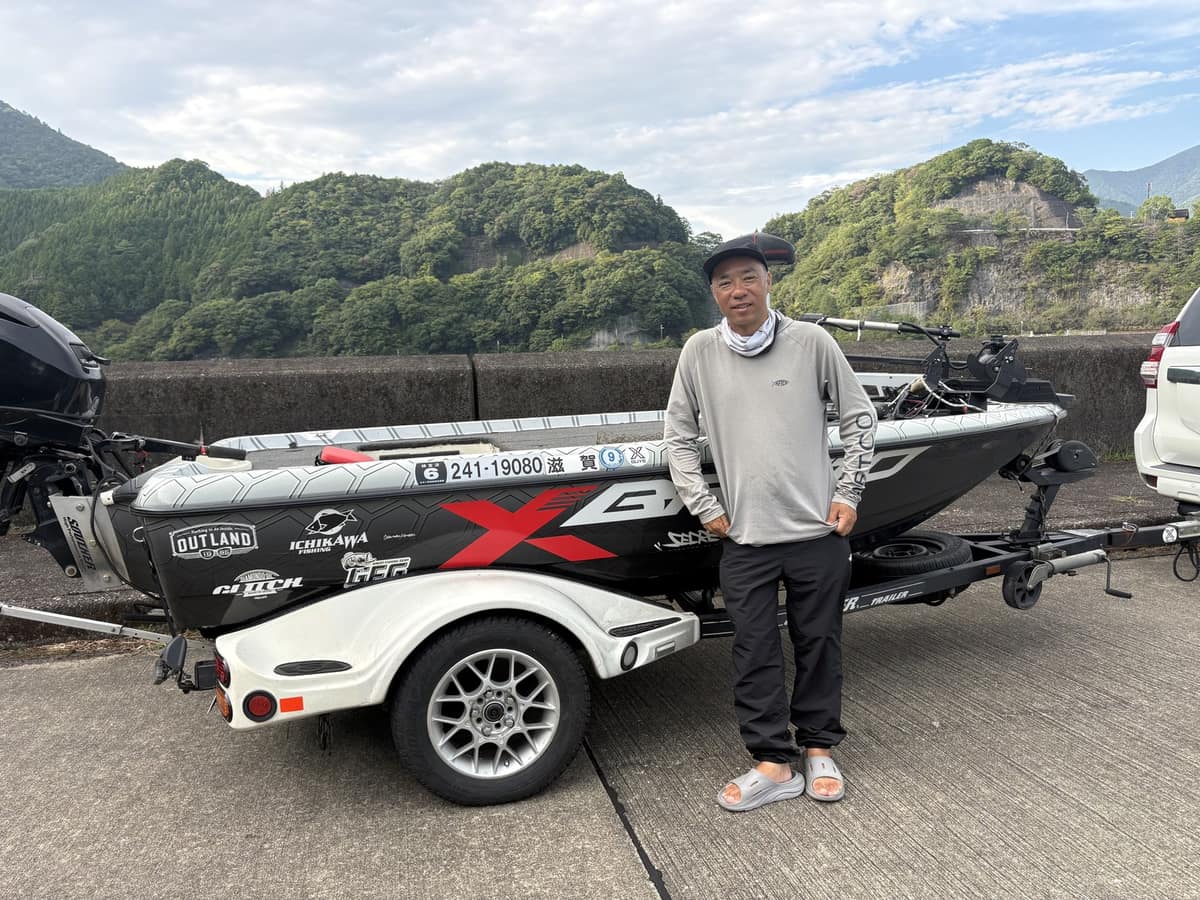 Takuji Chikamatsu standing beside his bass boat at Lake Ikehara, Nara, Japan