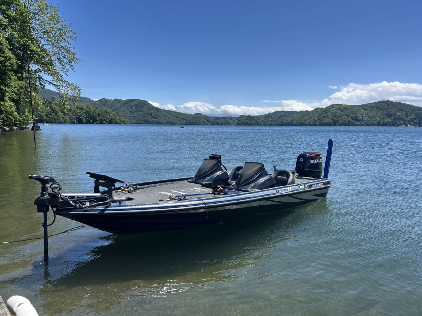 Yuki Kiyohama's bass boat moored on Lake Nojiri with green highland mountains behind