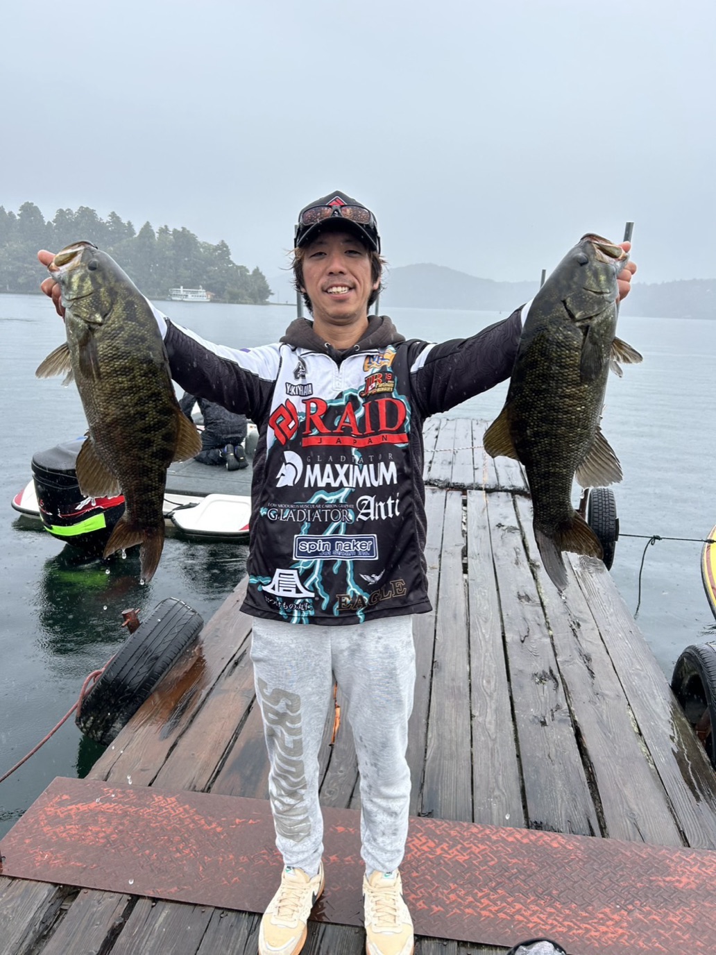Yuki Kiyohama, JB TOP50 professional angler, holding two smallmouth bass at Lake Nojiri, Nagano